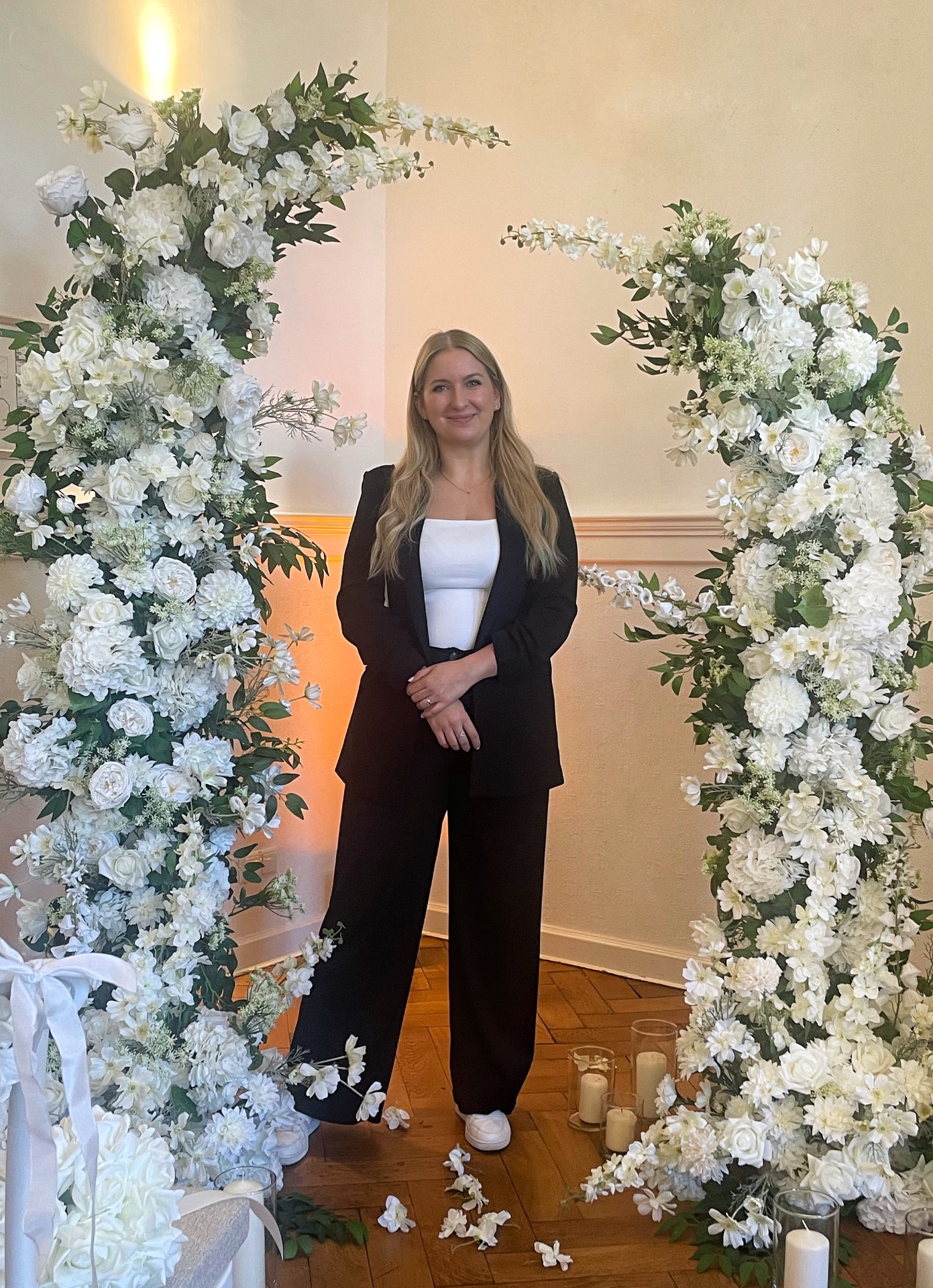 Dominique Lietz vor einem floralen Hochzeitsbogen
