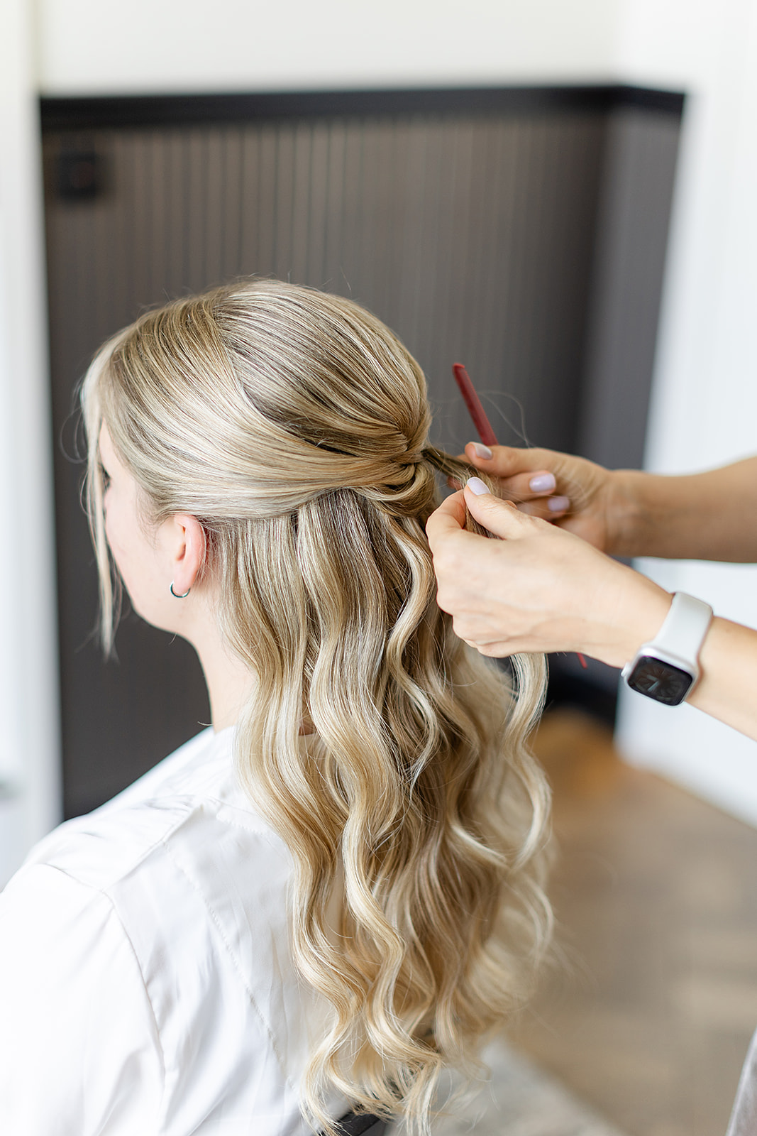 Braut beim Hairstyling im Getting-Ready-Zimmer