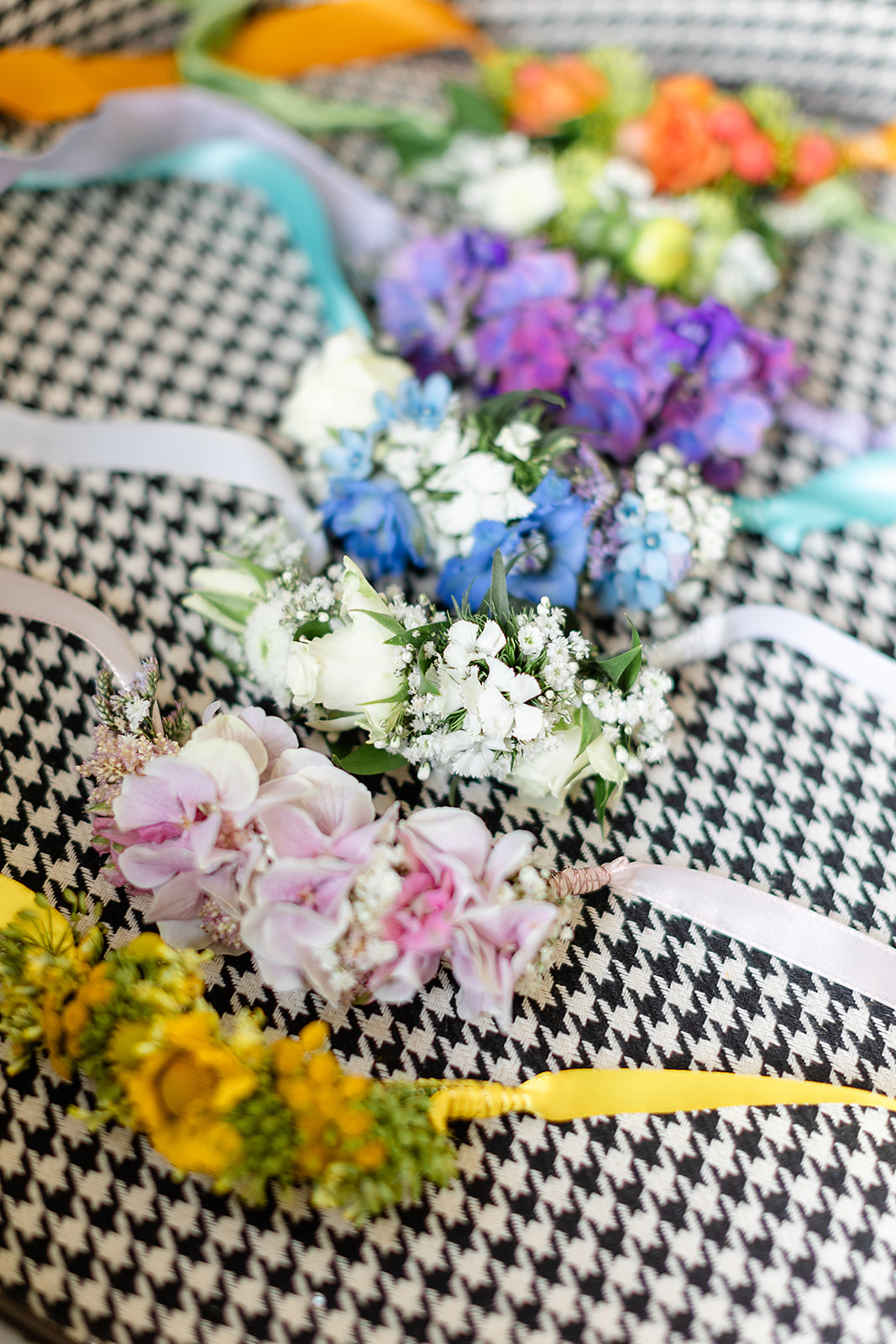 Farbige Blumen-Armbänder mit Satinbändern auf schwarz-weißem Muster
